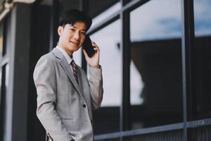 Good news about project. Young businessman talking with client via mobile phone and checking money transfer on tablet. Business, education, lifestyle concept photo