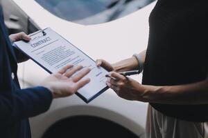 A young businesswoman is navigating car insurance options at her desk, considering premiums, deductibles, and coverage while understanding policies and managing claims efficiently. photo