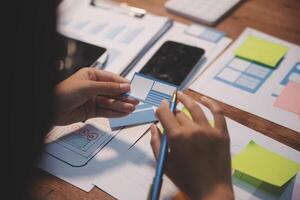 The designer team is designing the uxui system to make the uxui system work well on new phones and support system updates. Website development concept UI UX front end designer photo