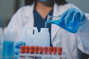 Group of dedicated scientist conduct chemical experiment in medical laboratory, carefully drop precise amount of liquid from pipette into test tube for vaccine drug or antibiotic development. Neoteric photo