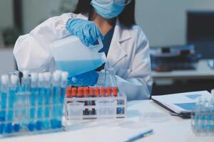 Group of dedicated scientist conduct chemical experiment in medical laboratory, carefully drop precise amount of liquid from pipette into test tube for vaccine drug or antibiotic development. Neoteric photo