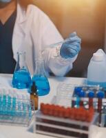 Group of dedicated scientist conduct chemical experiment in medical laboratory, carefully drop precise amount of liquid from pipette into test tube for vaccine drug or antibiotic development. Neoteric photo
