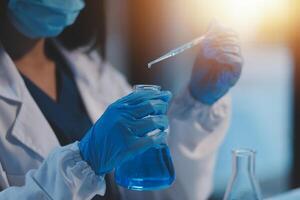 Group of dedicated scientist conduct chemical experiment in medical laboratory, carefully drop precise amount of liquid from pipette into test tube for vaccine drug or antibiotic development. Neoteric photo