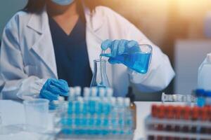 Group of dedicated scientist conduct chemical experiment in medical laboratory, carefully drop precise amount of liquid from pipette into test tube for vaccine drug or antibiotic development. Neoteric photo