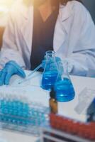 Group of dedicated scientist conduct chemical experiment in medical laboratory, carefully drop precise amount of liquid from pipette into test tube for vaccine drug or antibiotic development. Neoteric photo