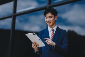 Businessman using tablet and enjoying in coffee break in front of the the corporation. Business, lifestyle concept photo
