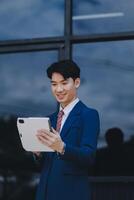 Businessman using tablet and enjoying in coffee break in front of the the corporation. Business, lifestyle concept photo