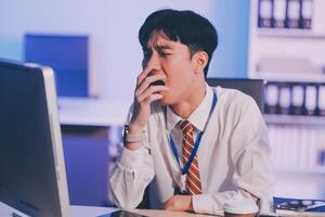 Businessman workaholic sit at the computer working late at night yawn tired and sleeping in the office,Hard work in the later time concept photo
