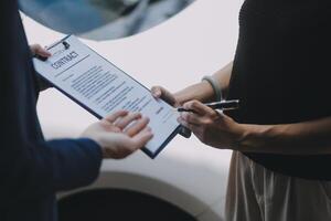 A young businesswoman is navigating car insurance options at her desk, considering premiums, deductibles, and coverage while understanding policies and managing claims efficiently. photo