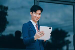 Businessman using tablet and enjoying in coffee break in front of the the corporation. Business, lifestyle concept photo
