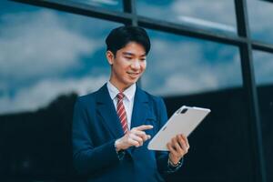 Businessman using tablet and enjoying in coffee break in front of the the corporation. Business, lifestyle concept photo