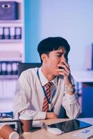 Businessman workaholic sit at the computer working late at night yawn tired and sleeping in the office,Hard work in the later time concept photo