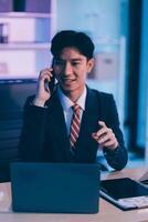 Serious trader using mobile phone app on smartphone for checking stock trading data analysis concept, focused businessman holding cellphone working in office with financial graph on computer monitors photo