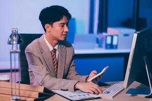 Business accounting concept Businessman uses calculator with laptop computer Budget and borrowed paper Calculate expenses, expenses, taxes online, manage company budgets, close-up images photo