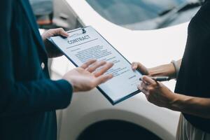 A young businesswoman is navigating car insurance options at her desk, considering premiums, deductibles, and coverage while understanding policies and managing claims efficiently. photo