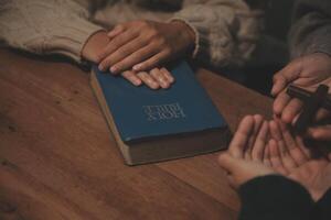 Christian group are praying to god with the bible and sharing the gospel. Concept of faith for god. photo