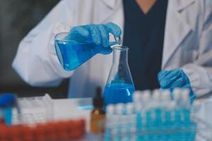 Group of dedicated scientist conduct chemical experiment in medical laboratory, carefully drop precise amount of liquid from pipette into test tube for vaccine drug or antibiotic development. Neoteric photo