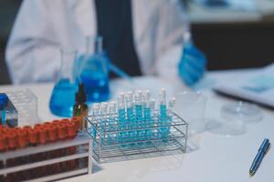 Group of dedicated scientist conduct chemical experiment in medical laboratory, carefully drop precise amount of liquid from pipette into test tube for vaccine drug or antibiotic development. Neoteric photo