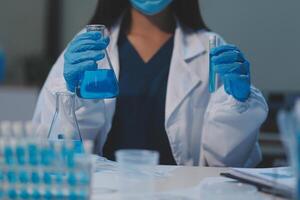 Group of dedicated scientist conduct chemical experiment in medical laboratory, carefully drop precise amount of liquid from pipette into test tube for vaccine drug or antibiotic development. Neoteric photo