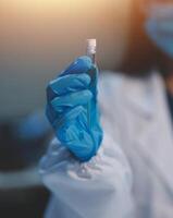 Group of dedicated scientist conduct chemical experiment in medical laboratory, carefully drop precise amount of liquid from pipette into test tube for vaccine drug or antibiotic development. Neoteric photo