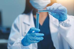 Group of dedicated scientist conduct chemical experiment in medical laboratory, carefully drop precise amount of liquid from pipette into test tube for vaccine drug or antibiotic development. Neoteric photo