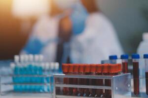Group of dedicated scientist conduct chemical experiment in medical laboratory, carefully drop precise amount of liquid from pipette into test tube for vaccine drug or antibiotic development. Neoteric photo