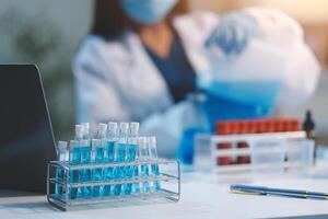 Group of dedicated scientist conduct chemical experiment in medical laboratory, carefully drop precise amount of liquid from pipette into test tube for vaccine drug or antibiotic development. Neoteric photo