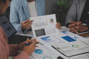Close up of Business team analyzing income charts and graphs with modern laptop computer. Business analysis and strategy concept. photo