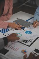 Close up of Business team analyzing income charts and graphs with modern laptop computer. Business analysis and strategy concept. photo