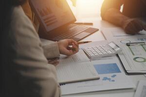 Close up of Business team analyzing income charts and graphs with modern laptop computer. Business analysis and strategy concept. photo
