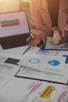 Close up of Business team analyzing income charts and graphs with modern laptop computer. Business analysis and strategy concept. photo
