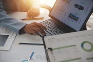 Close up of Business team analyzing income charts and graphs with modern laptop computer. Business analysis and strategy concept. photo
