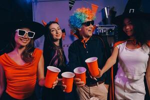 Joyful office Halloween party with coworkers in costumes, celebrating with drinks and laughter, fostering teamwork and festive spirit photo