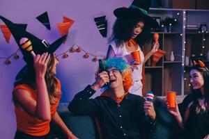 Joyful office Halloween party with coworkers in costumes, celebrating with drinks and laughter, fostering teamwork and festive spirit photo