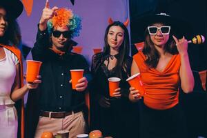 Joyful office Halloween party with coworkers in costumes, celebrating with drinks and laughter, fostering teamwork and festive spirit photo