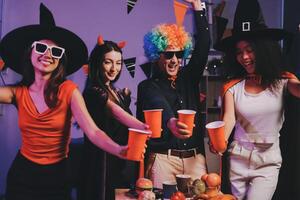 Joyful office Halloween party with coworkers in costumes, celebrating with drinks and laughter, fostering teamwork and festive spirit photo