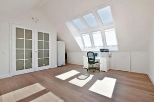 An empty room with a desk and a window photo