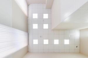 cassette stretched or suspended ceiling with square halogen spots lamps and drywall construction in empty room in house or office. Looking up view photo