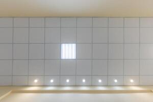 cassette stretched or suspended ceiling with square halogen spots lamps and drywall construction in empty room in house or office. Looking up view photo