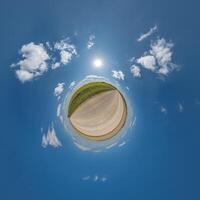 simple little tiny planet without buildings in blue sky with beautiful clouds. Transformation of spherical panorama 360 degrees. Spherical abstract aerial view. Curvature of space. photo