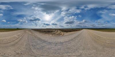 hdri 360 panorama on gravel road among fields in spring nasty evening before sunset in equirectangular full seamless spherical projection, for VR AR virtual reality content photo