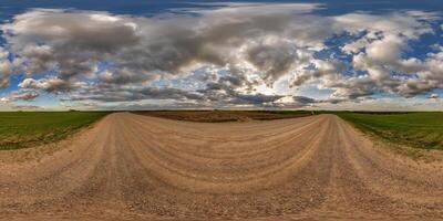 hdri 360 panorama on gravel road among fields in spring nasty evening before sunset in equirectangular full seamless spherical projection, for VR AR virtual reality content photo