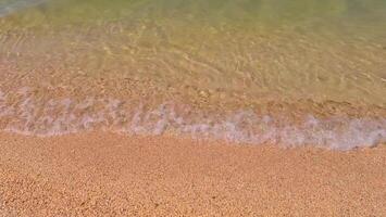 Serene beach and gentle, calm waves, yellow sand on a sunny day. Sandy beach, shore, close up top view. photo