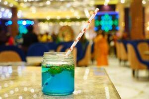 Close up refreshing classic mojito on the table with boken lights portrait background photo