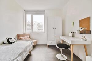 A bedroom with a desk and chair in it photo
