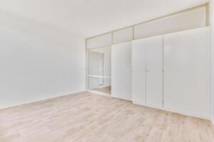 An empty room with white walls and wooden floors photo