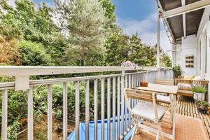 A balcony with a table and chairs on it photo