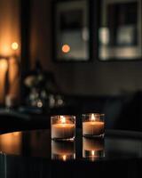A pair of candles flickering in the dim light, placed on a sleek black table photo