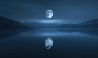 Bright full moon reflected in a still lake, distant hills barely visible in the darkness photo