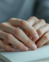 A person's hands resting on top of a book photo